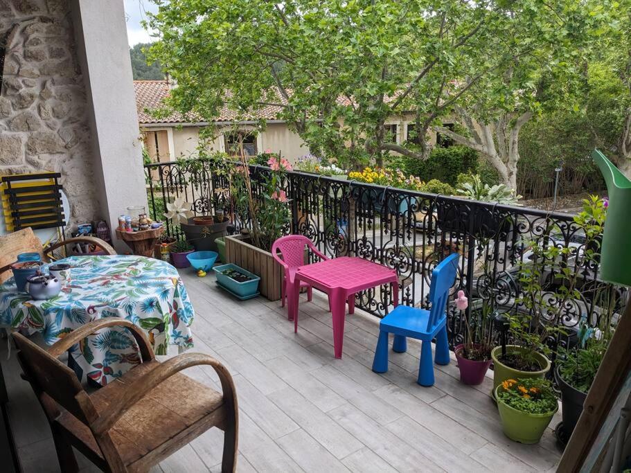 un patio avec des chaises et des tables colorées et une clôture dans l'établissement Jolie maison de village, à Grabels