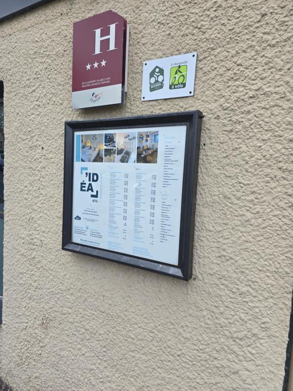 a sign on the side of a building with signs at Hôtel L'ideal le Mountbatten in Arromanches-les-Bains