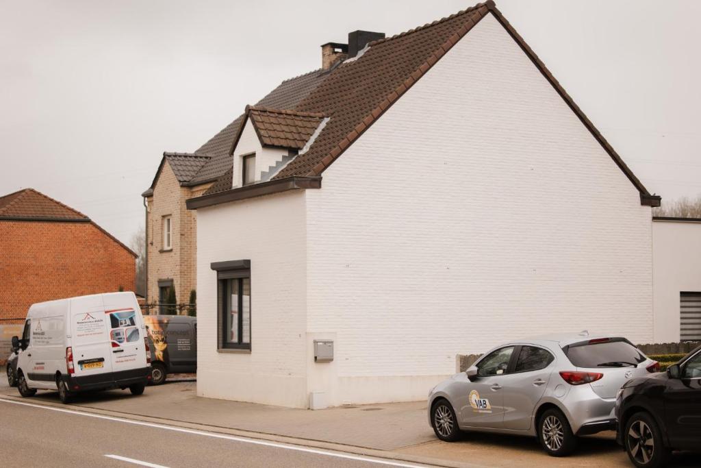 Una casa blanca con autos estacionados frente a ella. en Alivio - Thuiskomen bij jezelf op vakantie, en Lummen