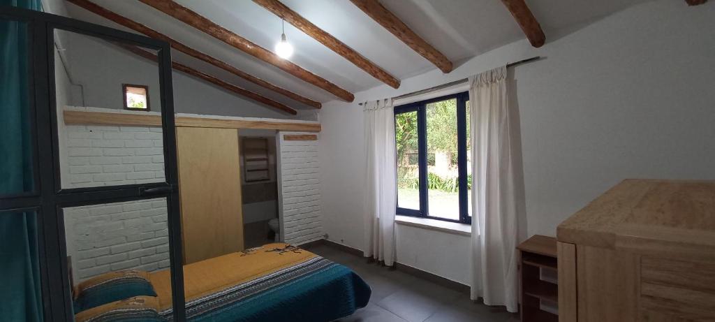 Habitación pequeña con cama y ventana en Finca El Recreo, en Tomatas