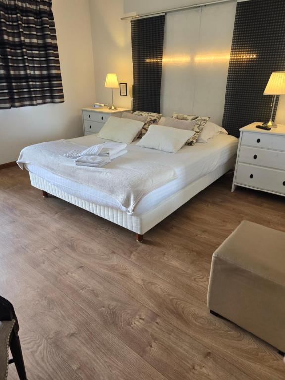 a bedroom with a large bed with white sheets and pillows at Hôtel L'ideal le Mountbatten in Arromanches-les-Bains