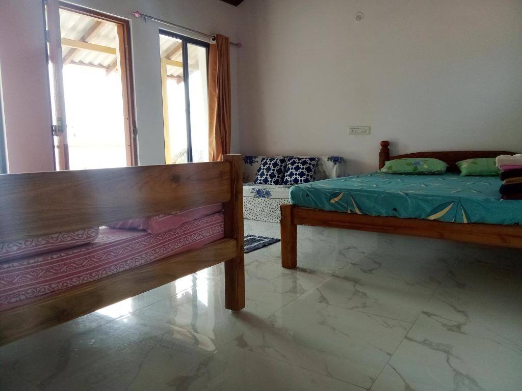 um quarto com 2 camas e uma janela em Gajananstay Beach facing Rooms Indians only em Gokarn