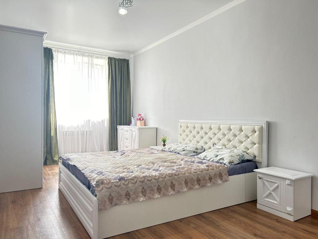 a white bedroom with a large bed and a window at Абылай хана in Zaozërnyy