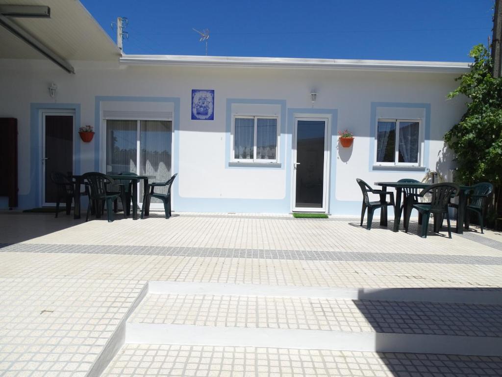 a patio with tables and chairs in front of a building at Casinha do Mar in Carvide