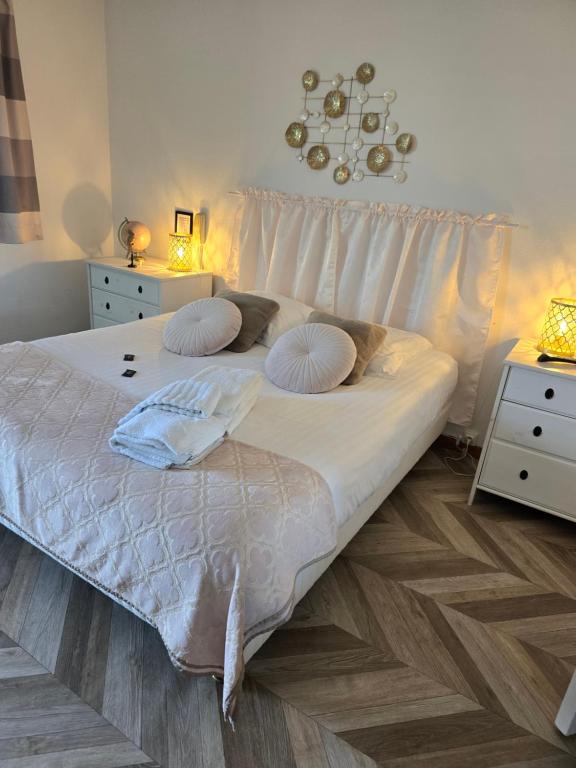a bed with white sheets and pillows in a bedroom at Hôtel L'ideal le Mountbatten in Arromanches-les-Bains