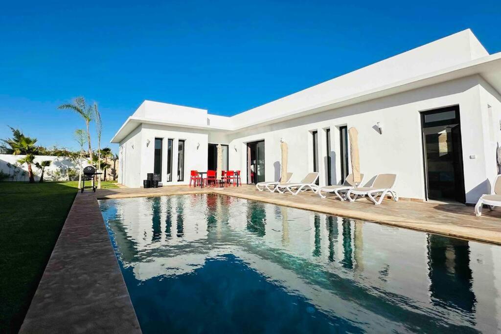 une maison blanche avec une piscine devant dans l'établissement Villa Darline Maison Design Piscine chauffée, à Essaouira