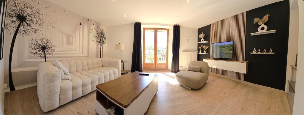 un salon avec un canapé blanc et une table dans l'établissement 2 Pieces entièrement rénovés proche du lac, à Veyrier-du-Lac