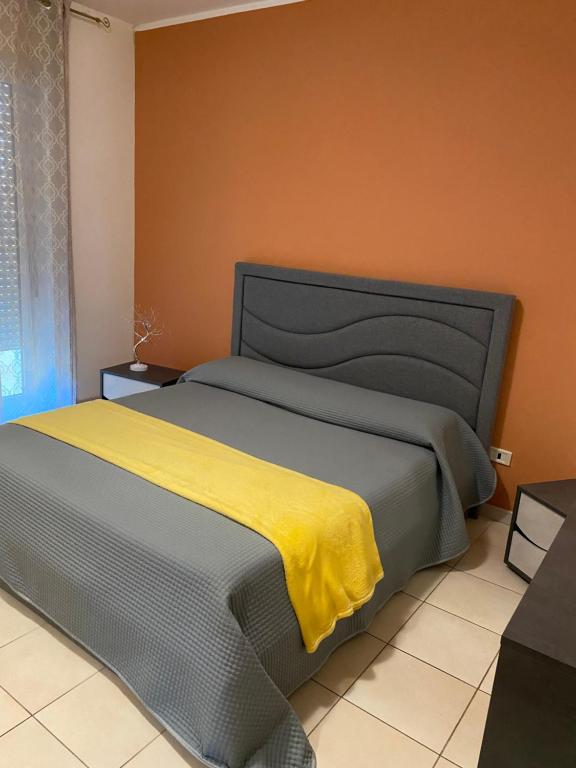 um quarto com uma cama com um cobertor amarelo em Villetta Susy em Valrovina