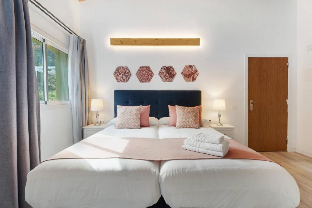 ein Schlafzimmer mit einem großen weißen Bett mit Kissen in der Unterkunft Comfort apartment Casa Lomo El Aire Acevino with outdoor pool in Tegueste