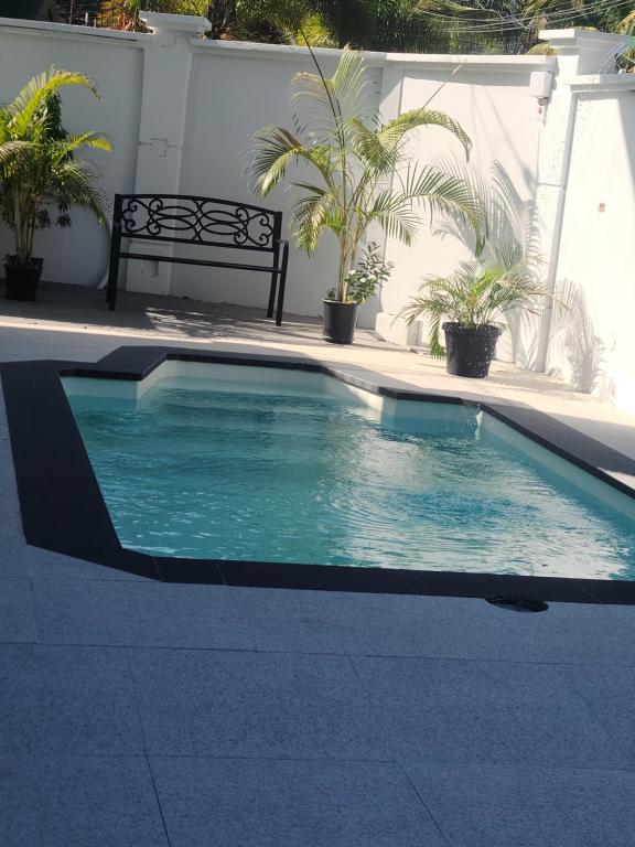 een zwembad met een bank in een tuin bij Riverside Apartments in San Juan