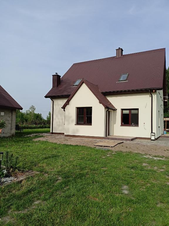 een wit huis met een zwart dak bij U Stasia in Uścimów