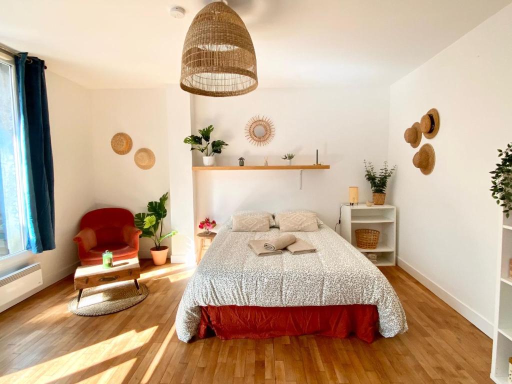 une chambre avec un lit et une chaise dans l'établissement Charmant studio proche du théâtre, à Tours