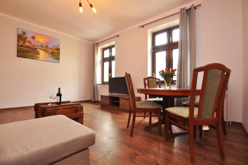 een woonkamer met een tafel en een televisie bij Słoneczny Apartament przy Rynku in Wrocław