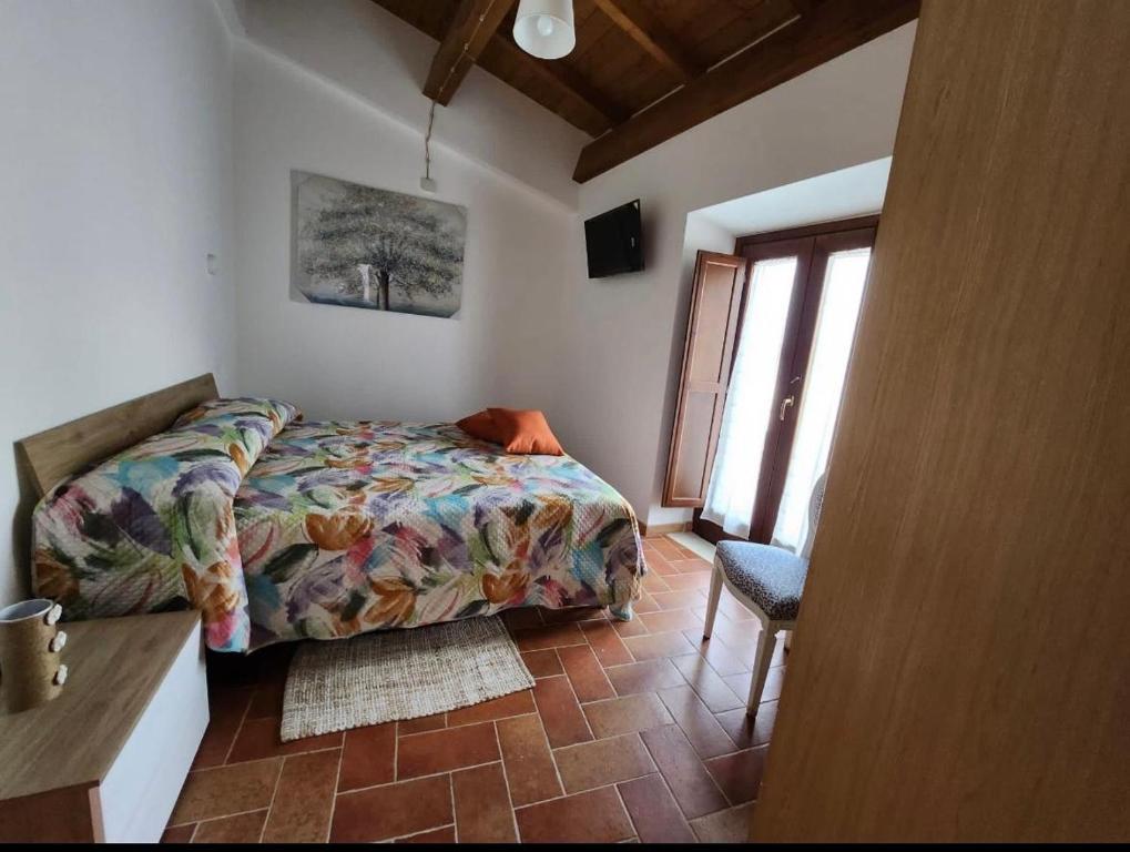 1 dormitorio con 1 cama, 1 silla y 1 ventana en B&B Tussillo, 