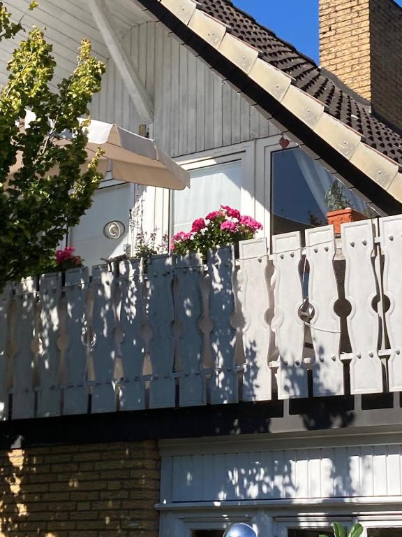 a white fence on a house with flowers on it at Gästewohnung 25 in Wildeshausen