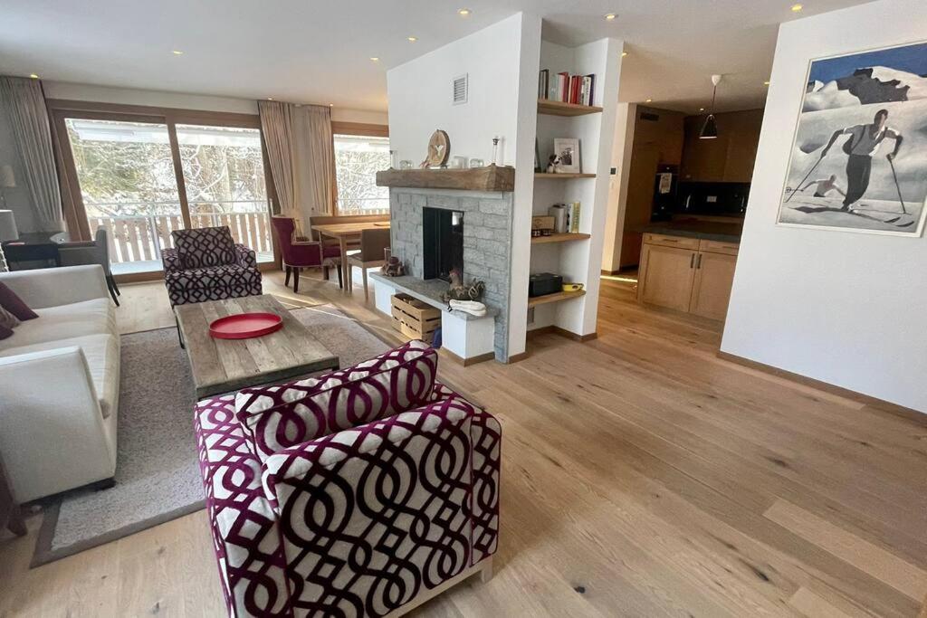uma sala de estar com uma mesa e uma lareira em Elegant apartment in Flims close to Lake Caumasee em Flims