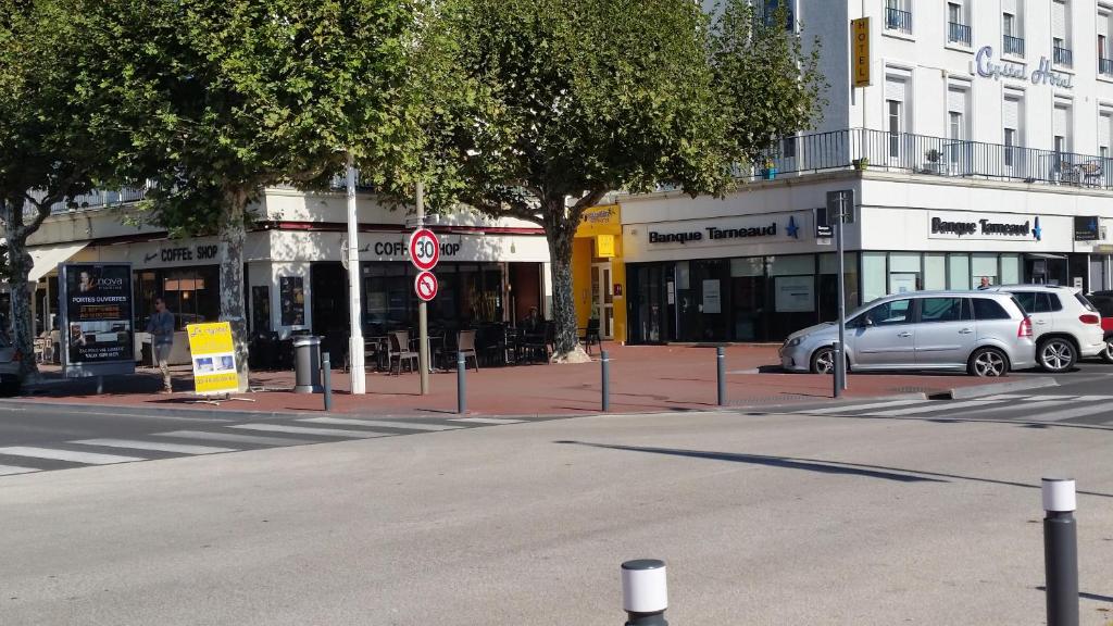 a street with cars parked in front of buildings at Crystal Hotel in Royan