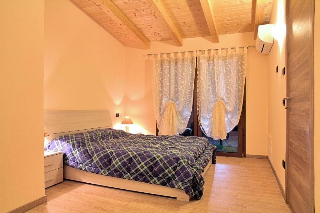 a bedroom with a bed and a window with curtains at Schöne Wohnung in Venedig mit Garten und Grill - b57251 in Tessera