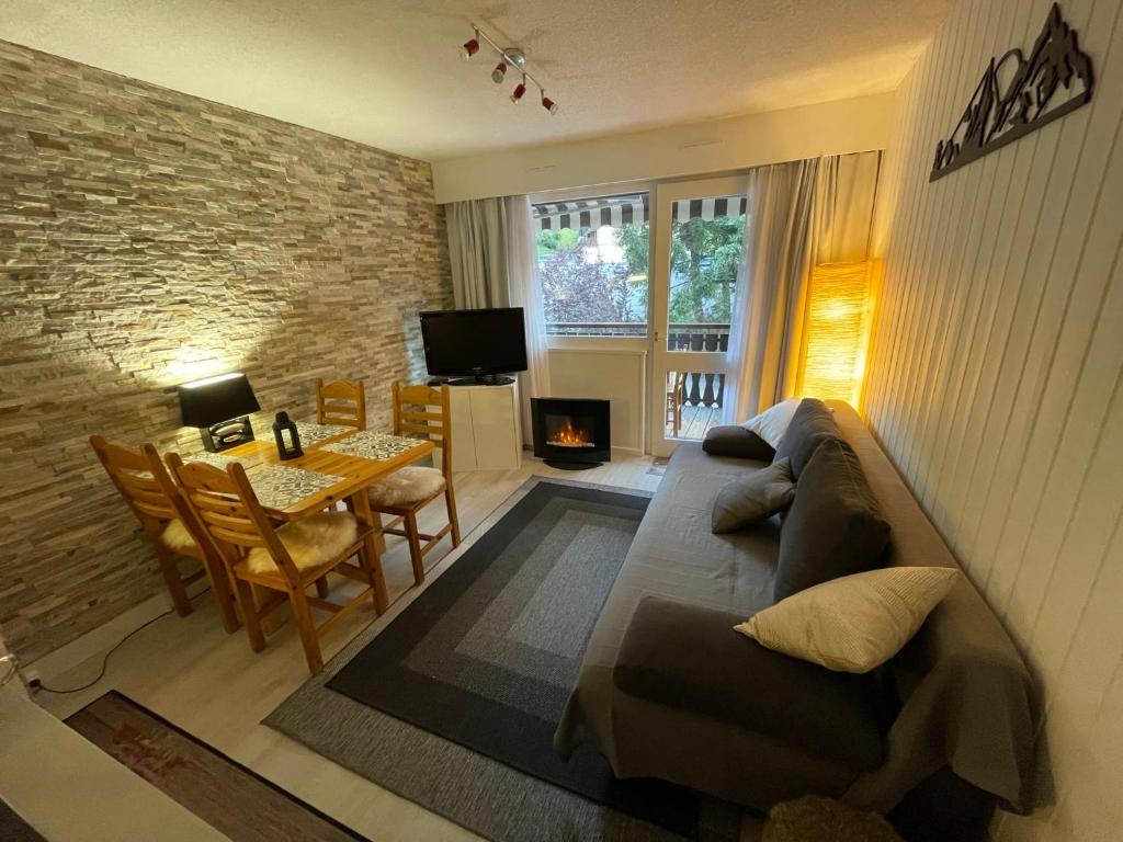 a living room with a couch and a table at Cosy 2 pièces proche Châtel in Abondance