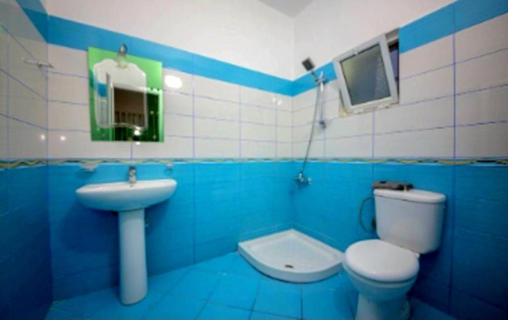 a blue and white bathroom with a toilet and a sink at Residence Vera in Ksamil