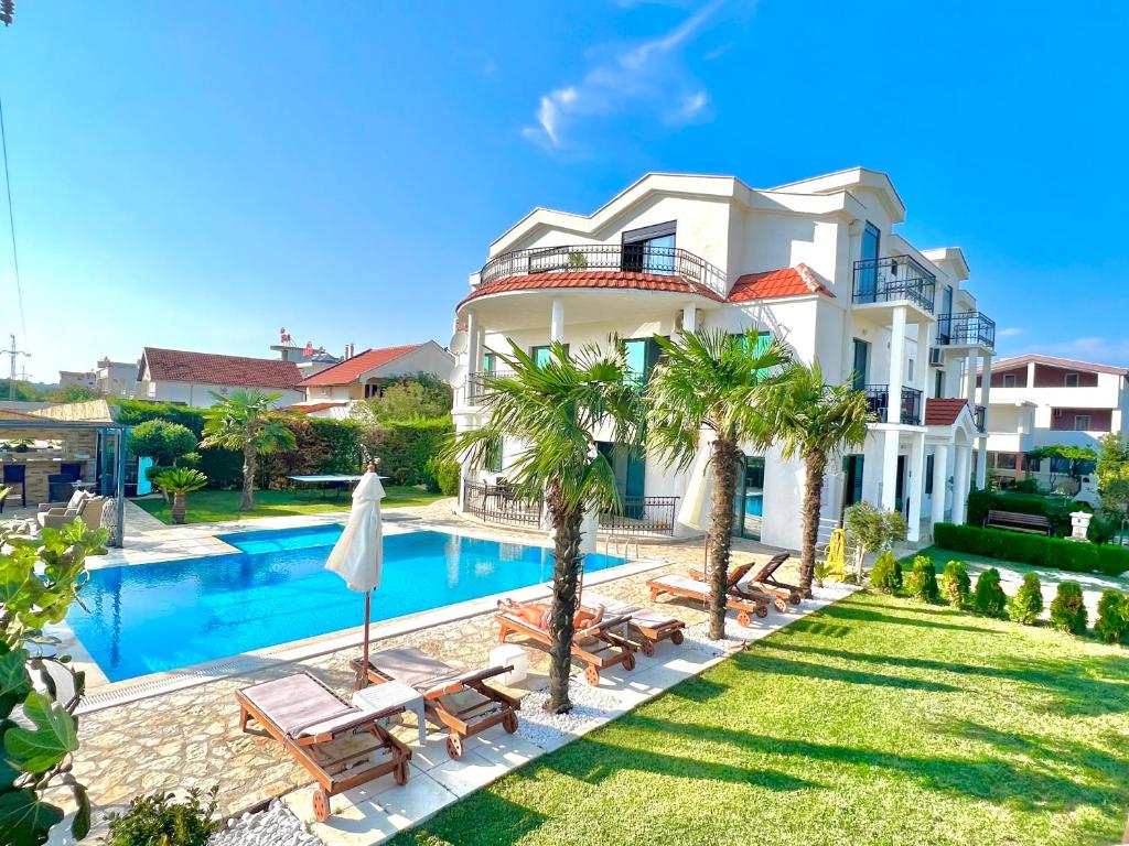 a villa with a swimming pool and palm trees at Apartments Lj in Ulcinj
