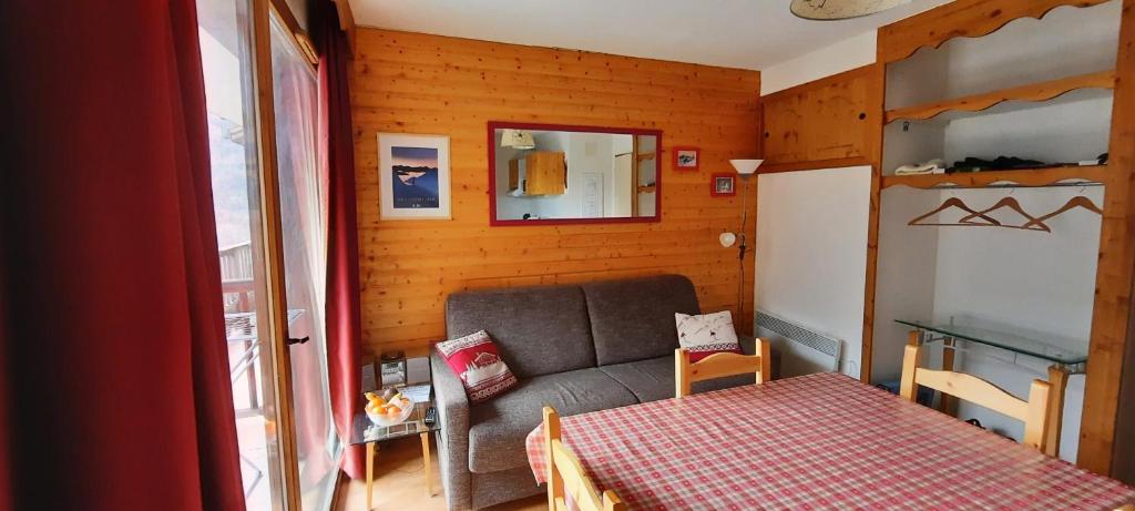 ein kleines Zimmer mit einem Sofa und einem Bett in der Unterkunft Orelle Val Thorens Appartement 2 pieces 5 personnes aux portes du Parc de la Vanoise in Orelle