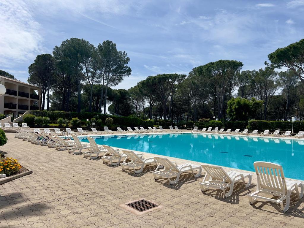 una fila de tumbonas y una piscina en Appartement 4 Personnes dans Résidence Golf de Valescure 2, en Saint-Raphaël