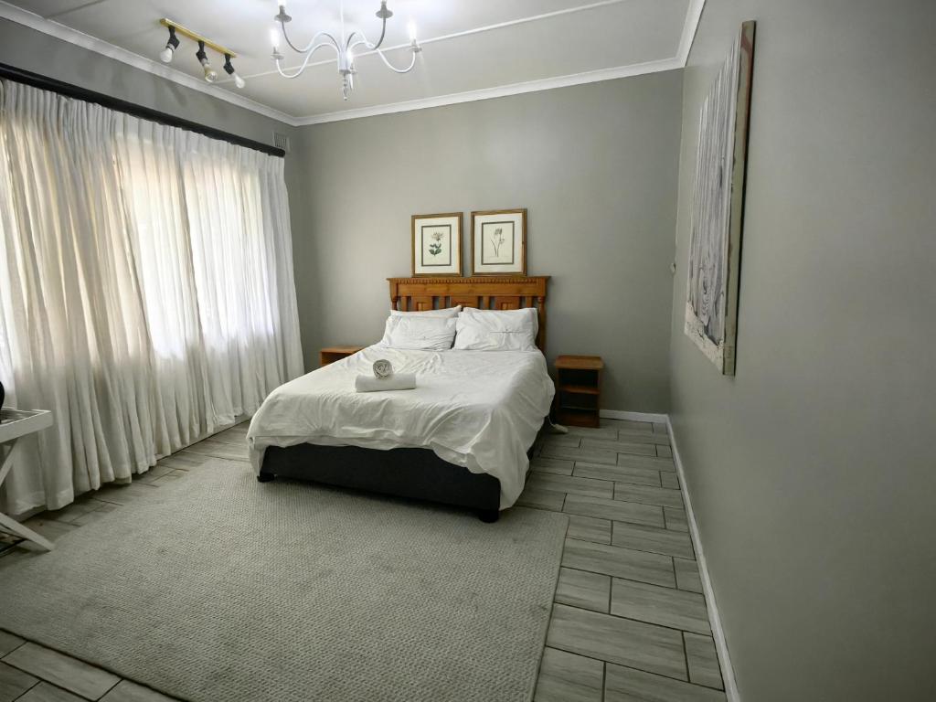 a bedroom with a bed and a chandelier at Mitchell Guesthouse in Pietermaritzburg