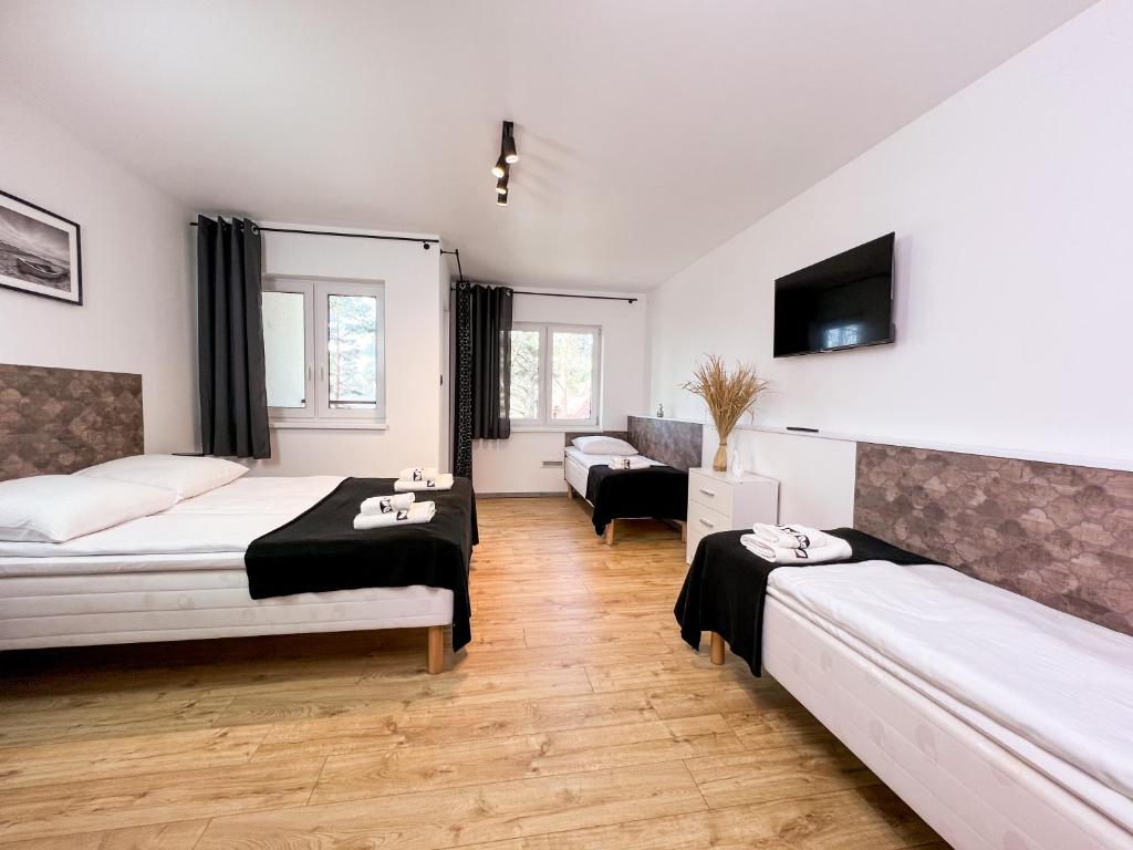 a bedroom with two beds and a living room at RAJSKA PLAZA Poddąbie Basen odkryty brodziki Basen kryty Plac zabaw Animacje in Poddąbie