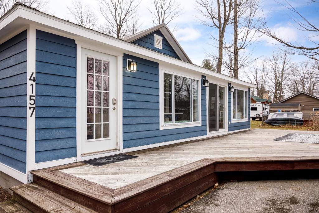 una casa con una casa blu con un ponte di Green Lake Central Cottage a Interlochen