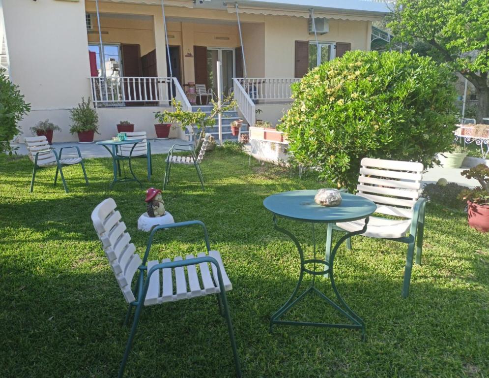 a group of chairs and a table in the yard at Finikas Rooms in Agia Marina Aegina