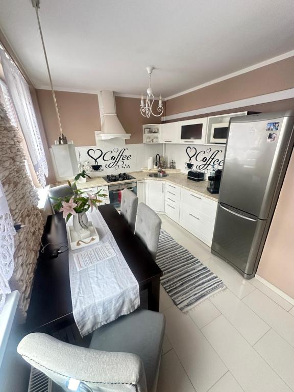 una cucina con frigorifero, tavolo e sedie di Apartament w centrum a Świebodzin