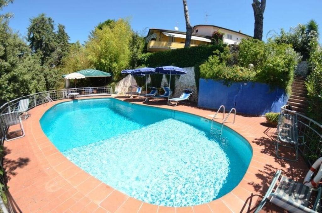 - une piscine dans une cour avec une maison dans l'établissement Ferienhaus mit Privatpool für 8 Personen ca 180 qm in Massarosa, Toskana Provinz Lucca, à Massarosa