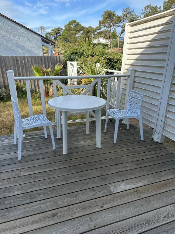 a white table and two chairs on a deck at Villa MA&amp;VA in Lacanau-Océan