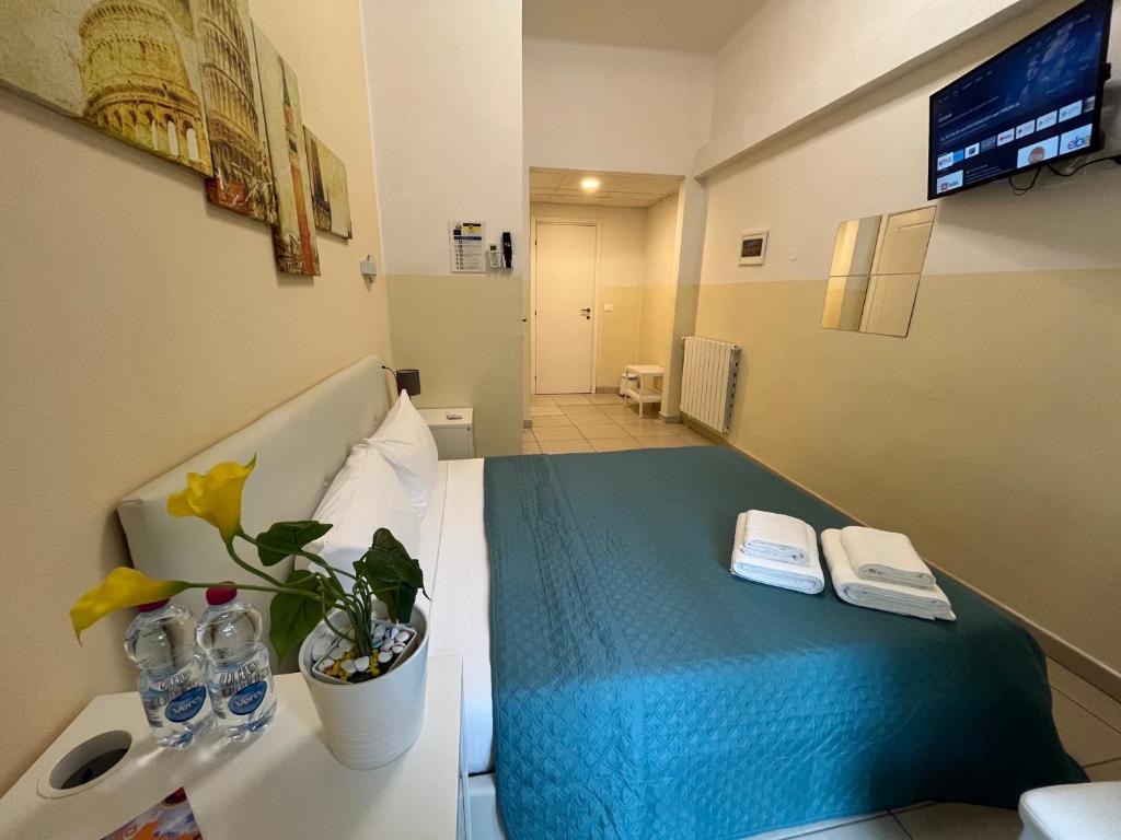 Habitación de hotel con cama con manta azul en Hello Pisa B&B en Pisa