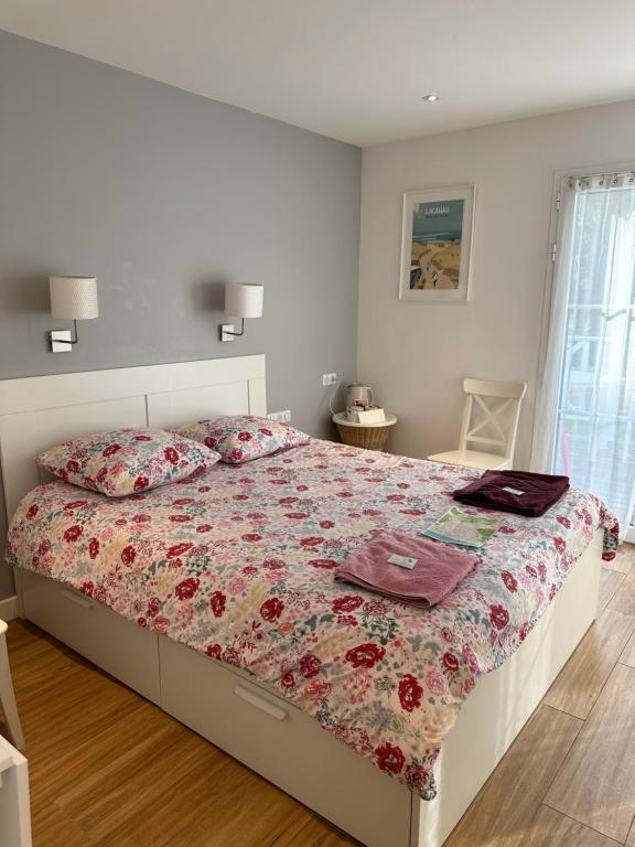 a bedroom with a bed with a floral comforter at Villa MA&amp;VA in Lacanau-Océan