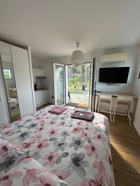 a bedroom with a bed with a floral bedspread at Villa MA&amp;VA in Lacanau-Océan