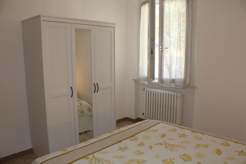 sypialnia z łóżkiem, oknem i drzwiami w obiekcie Appartamenti Sirolo 60020 w mieście Sirolo