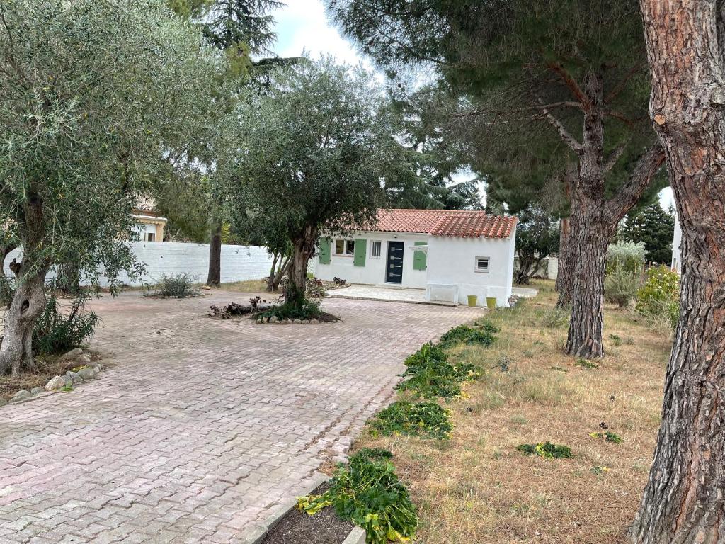 una casa con una entrada de ladrillo y árboles en Maison plain pied au calme sur parcelle arborée, en Argelès-sur-Mer