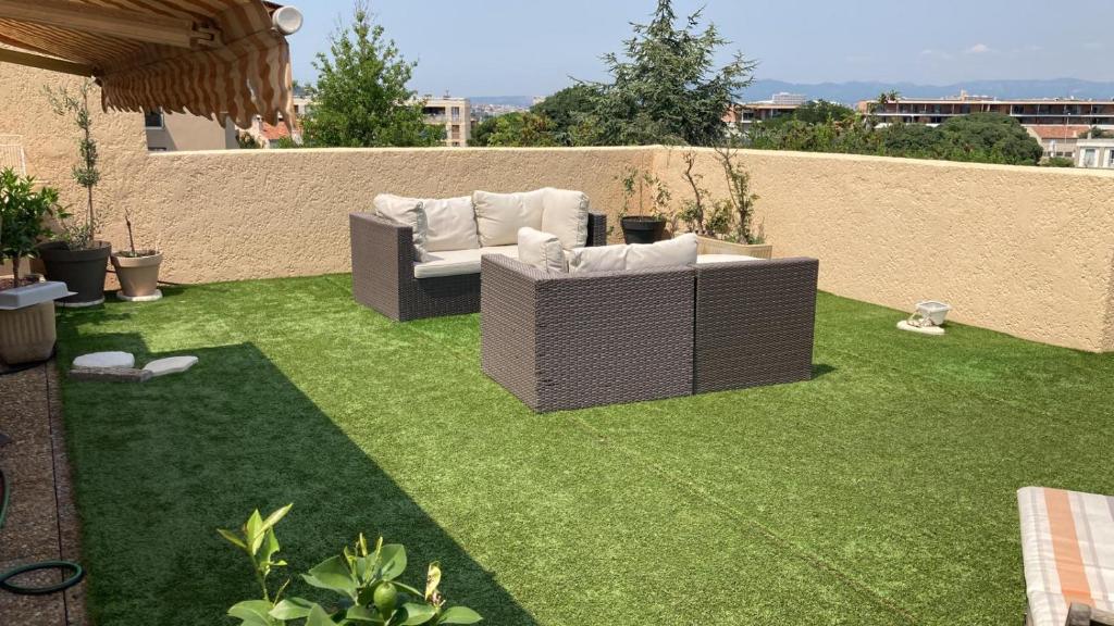 une pelouse avec un canapé installé au-dessus dans l'établissement Apparemment rooftop marseille, à Marseille
