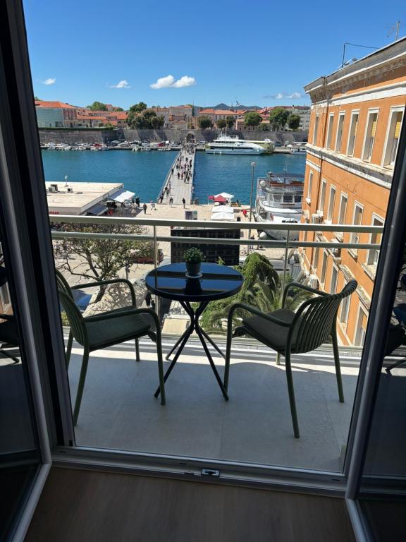 einen Balkon mit einem Tisch und Stühlen sowie Hafenblick in der Unterkunft Aurum Ponte Deluxe in Zadar