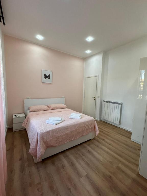 um quarto com uma cama e piso em madeira em STATION AND AiRPORT ROOM'S em Pisa