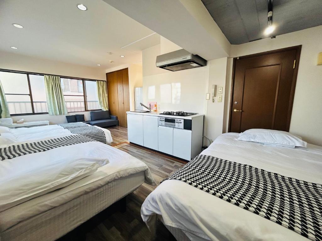 a hotel room with two beds and a kitchen at Ueno Iriya hostel in Tokyo