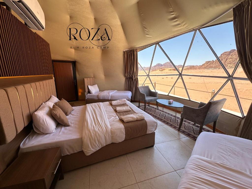 a hotel room with two beds and a view of the desert at Rum Roza luxury camp in Wadi Rum