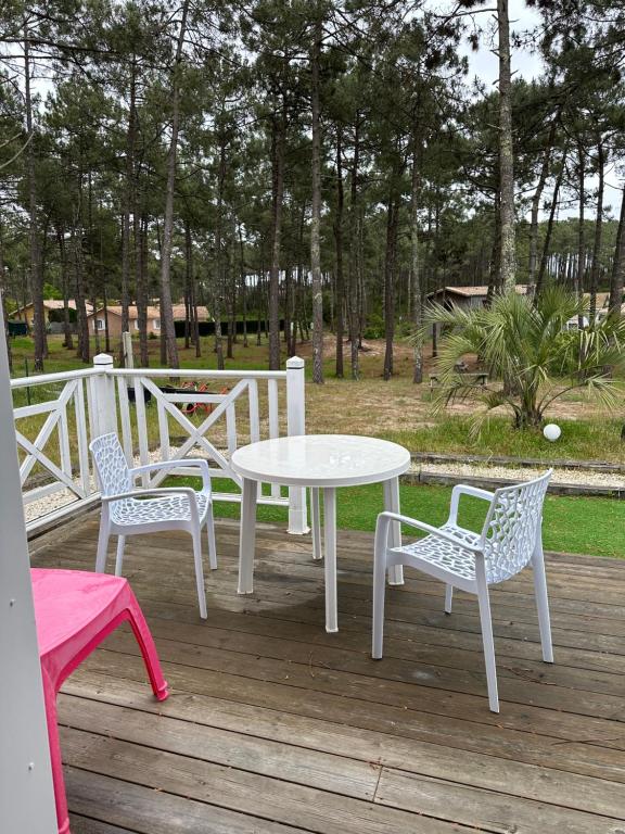 a white table and chairs on a wooden deck at Villa MA&VA in Lacanau-Océan