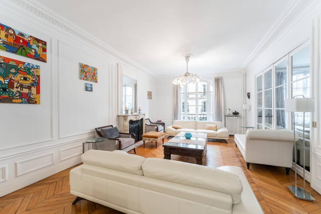 un salon blanc avec un canapé et une table dans l'établissement Appartement fabuleux - 16eme, à Paris