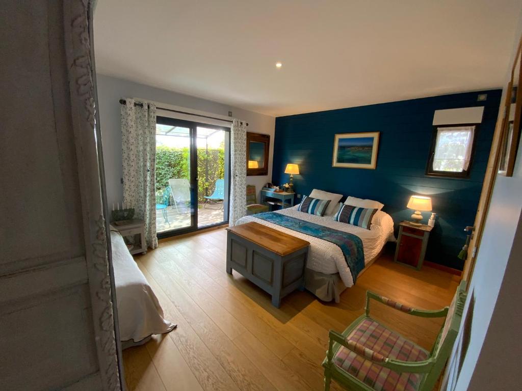 una camera con un letto con una parete blu di Villa Chamarel a Carcès