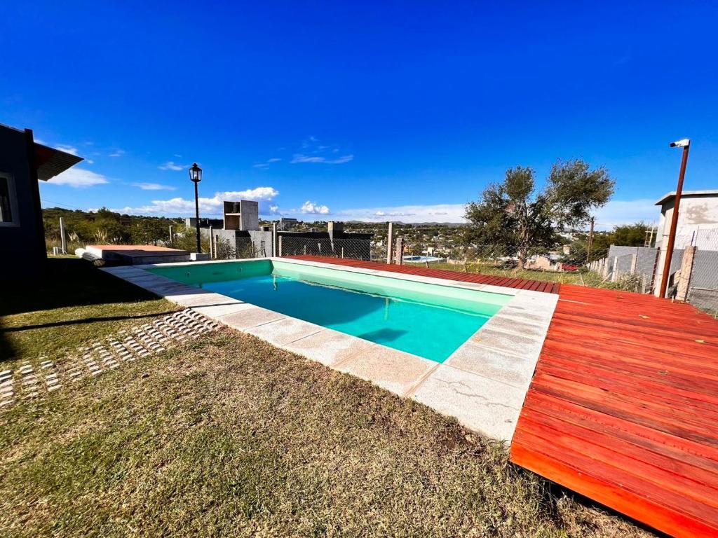 una piscina en un patio con un banco de madera en El 8 del mirador en Villa Santa Cruz del Lago