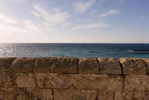 a stone wall with the ocean in the background at appartamento a 100 m. dal mare in Gallipoli
