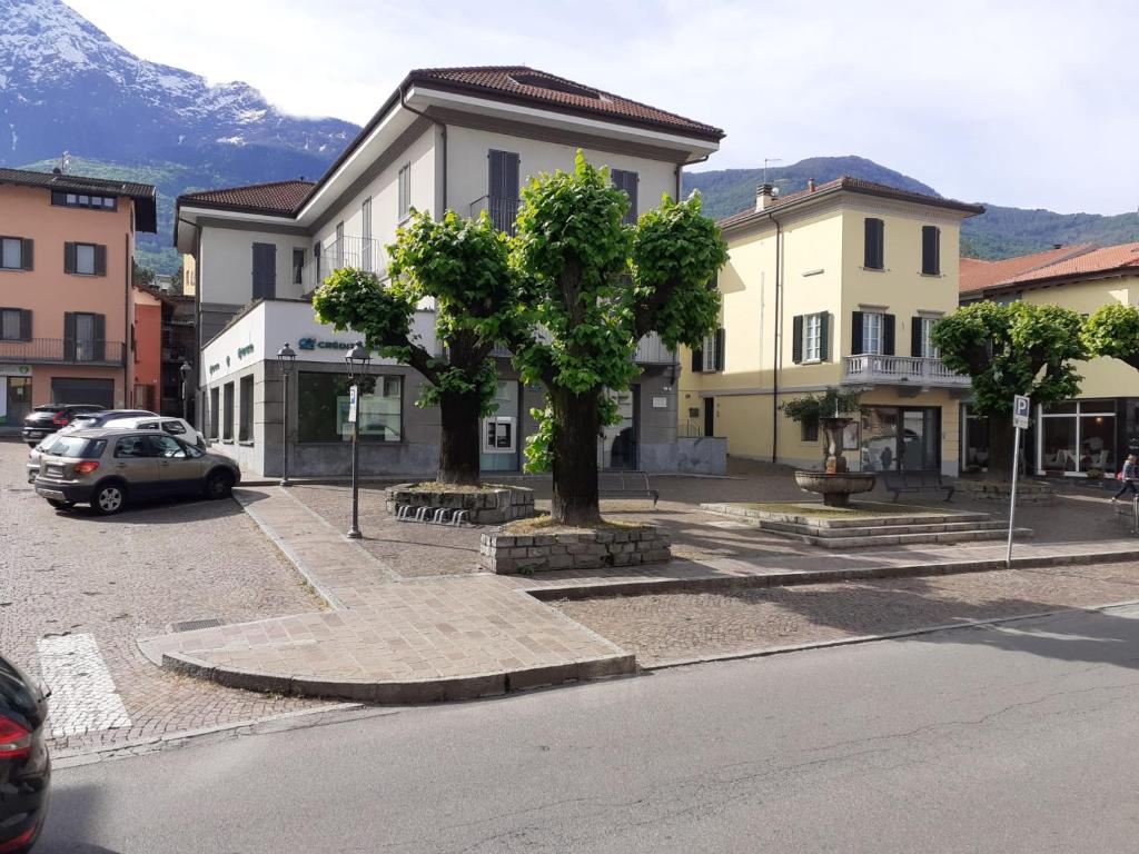 a building with a tree in the middle of a street at Appartamento Scoggione in Colico
